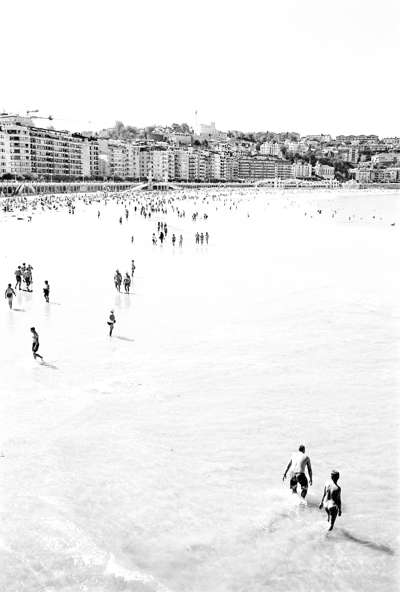 des silhouettes de baigneurs sur la plage de san sebastian, photo argentique en noir et blanc