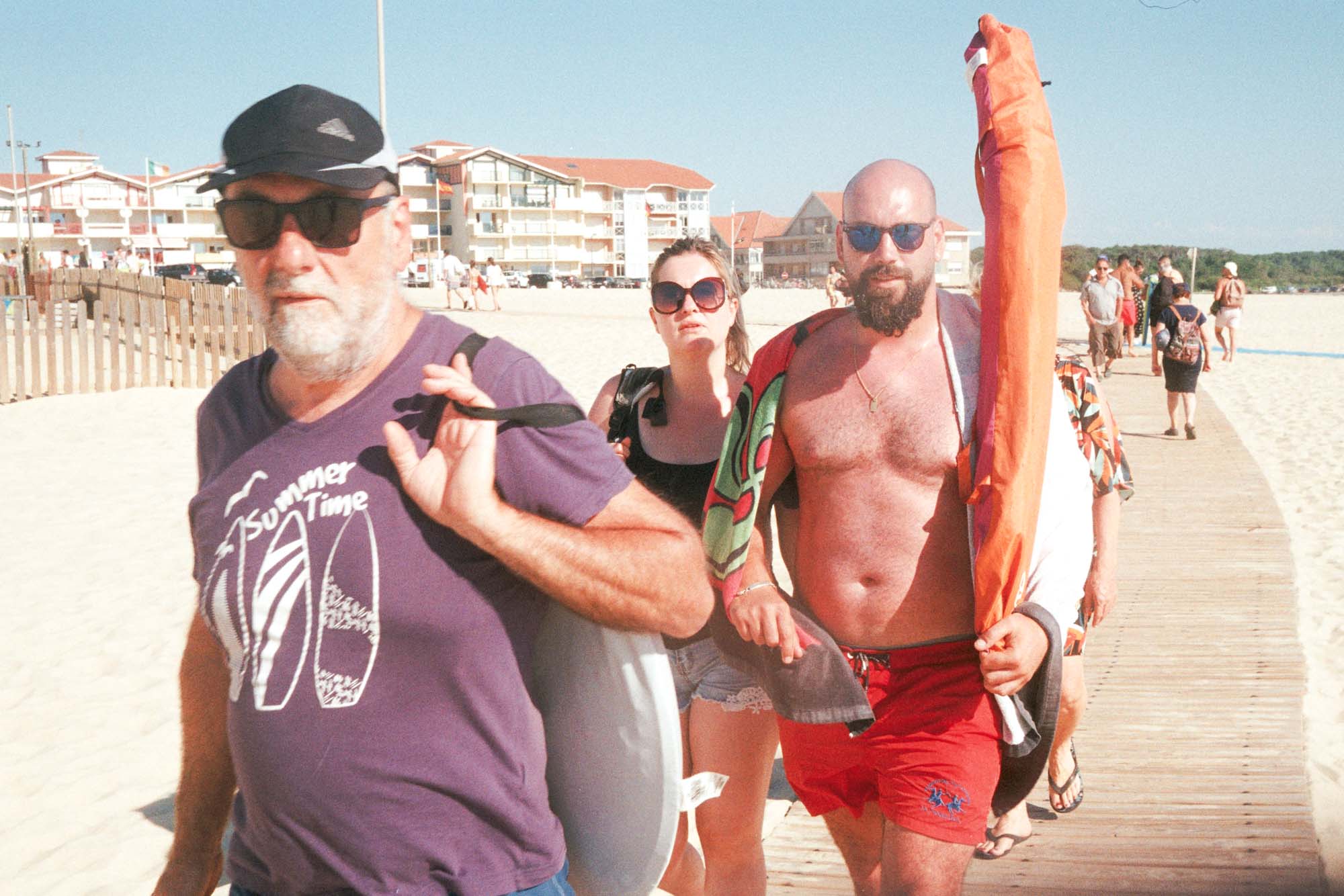des touristes rejoigent la plage sud de Vieux-BOUCAU en suivant un chemin en bois posé sur le sable et me regardent. ils plrtent du matériel de plage