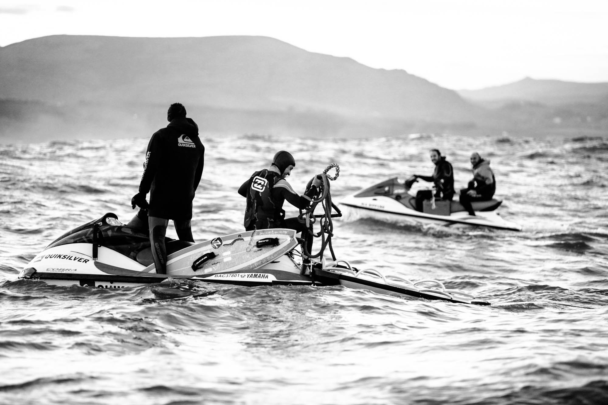 les équipages sont sur leurs jet ski avec leurs planches de surf et sortent les cordes pour tracter, on voir plusieurs jet skis et les gens discutent