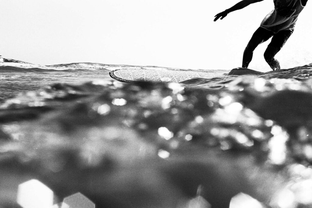 Jambes d'un surfeur en contre-plongée sur une planche, tirage d'art argentique noir et blanc "Brillance", MonVilain