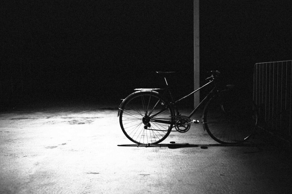 Vélo isolé sous un lampadaire la nuit, tirage d'art argentique noir et blanc "La Nuit Je Mens", MonVilain
