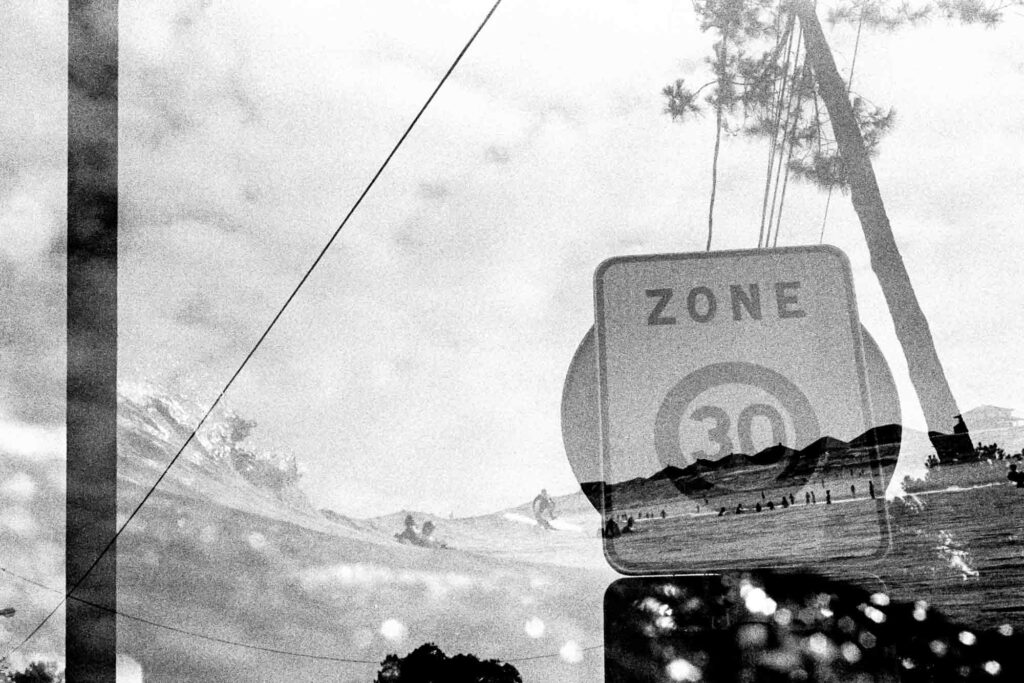 Double exposition d'un panneau Zone 30 superposé à une vague et un surfeur, tirage d'art argentique noir et blanc "Zone30", MonVilain