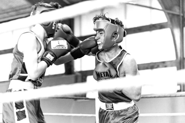 un boxeur frappe un autre sur un ring, on voit le protege dent