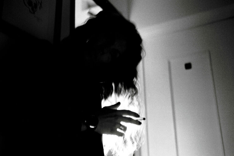 on devine une silhouette de femme qui tient une cigarette à la main