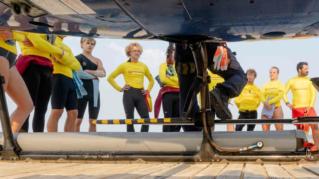 Nageurs-sauveteurs attendant au flanc de l'hélicoptère, palmes à la main