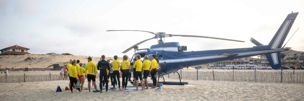 Équipe de nageurs-sauveteurs face à l'hélicoptère posé sur la plage de Vieux-Boucau
