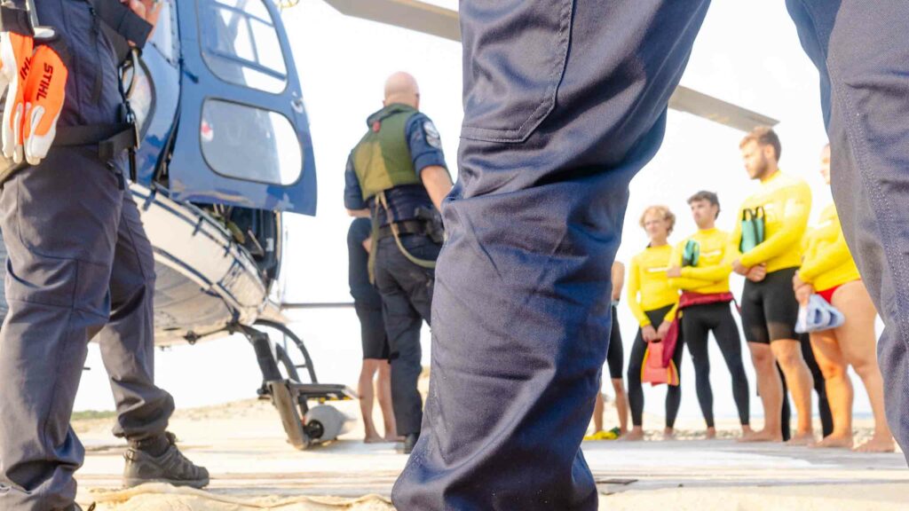 Gendarme du SAG Mérignac équipé au sol près de l'hélicoptère, nageurs-sauveteurs en arrière-plan