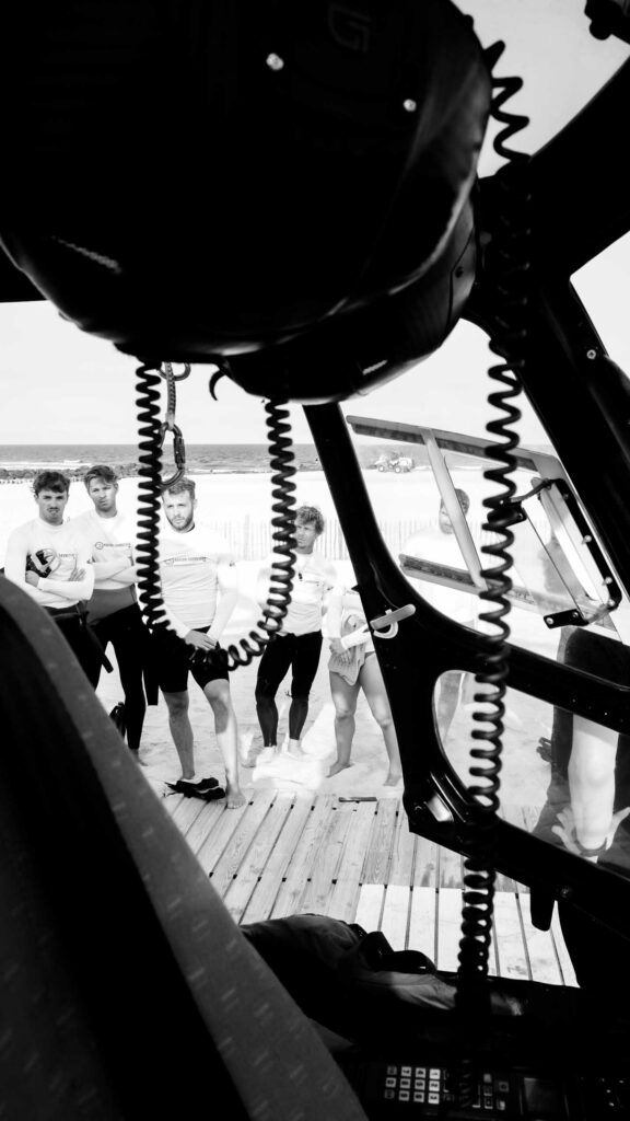 Équipe de nageurs-sauveteurs regroupée sous l'hélicoptère avant l'exercice d'hélitreuillage
