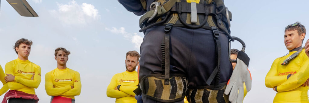 Détail du harnais d'un gendarme, équipe de nageurs-sauveteurs en arrière-plan