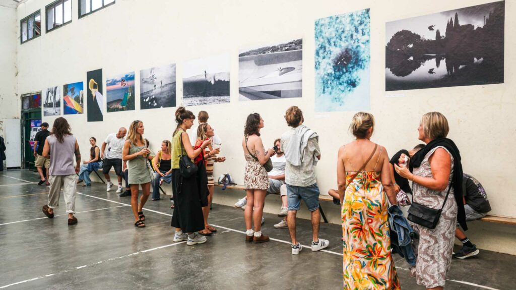 Foule de visiteurs devant les tirages photo exposés au Mur à Gauche, Board Culture Exposure Biarritz
