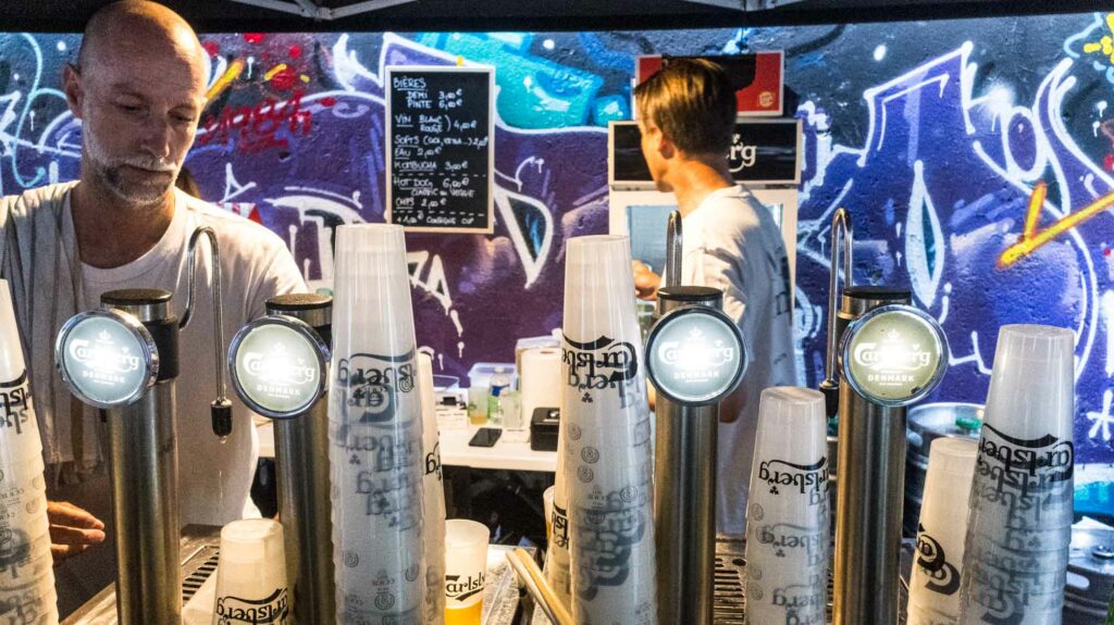 Bar avec tireuses à bière Carlsberg et fresque graffiti, ambiance Summer Block Party Biarritz