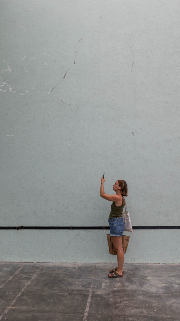 Femme photographiant un mur d'exposition vide au Mur à Gauche, Biarritz